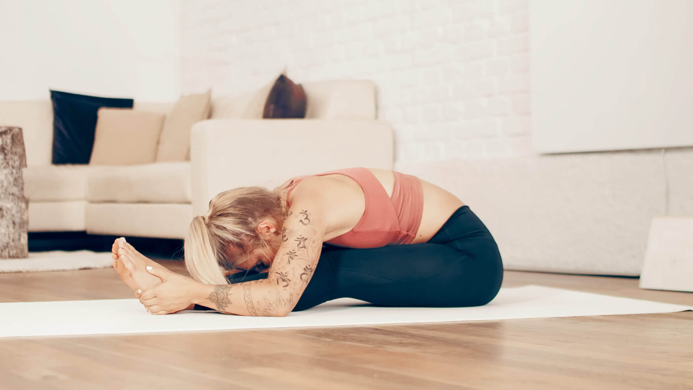 Kati bei der Yoga Übung Sitzende Vorbeuge — Paschimottanasana